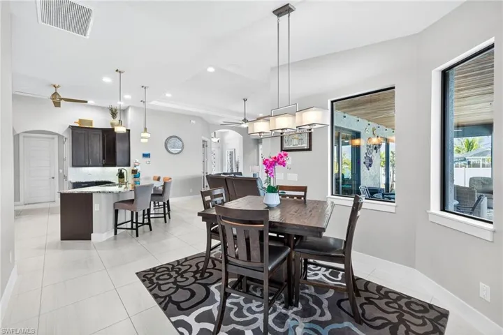 Dining area featuring arched walkways, recessed lighting, light tile patterned flooring, and a ceiling fan