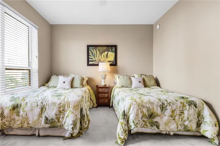 Carpeted bedroom featuring a ceiling fan