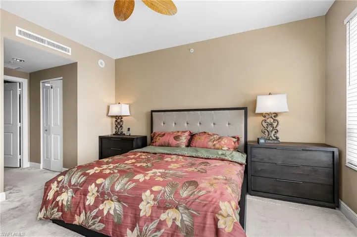 Carpeted bedroom featuring ceiling fan and a closet