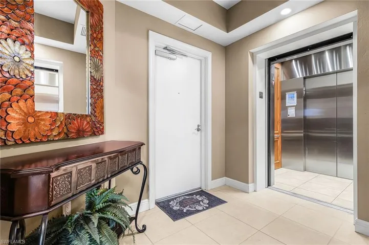 Foyer entrance with elevator and light tile patterned floors