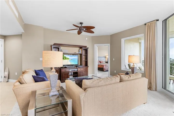 Living room featuring healthy amount of natural light, a ceiling fan, and light tile patterned floors