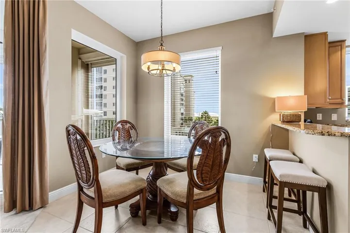 Dining room with light tile patterned floors and a chandelier