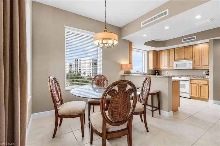 Dining area featuring a chandelier, light tile patterned flooring, and recessed lighting