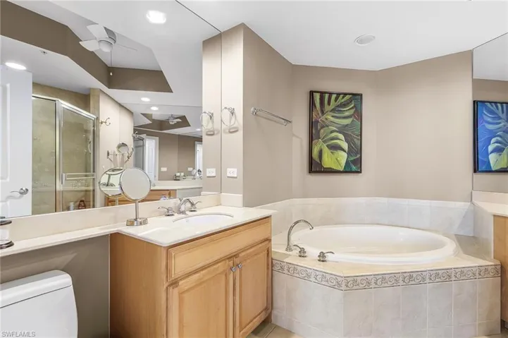 Full bath with vanity, a stall shower, a garden tub, recessed lighting, and ceiling fan