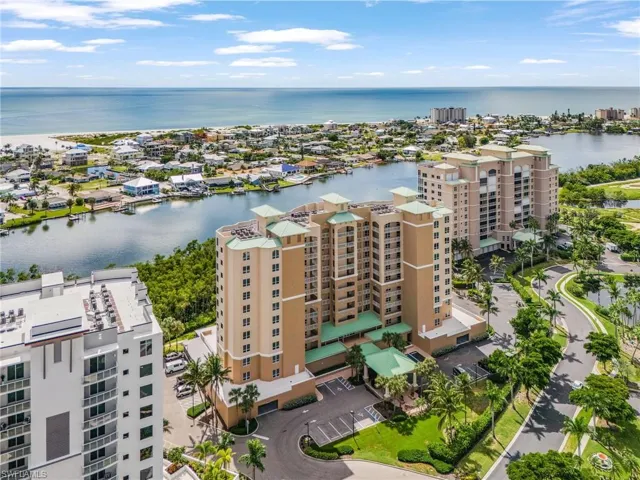 Drone / aerial view of apartment complex and a large body of water