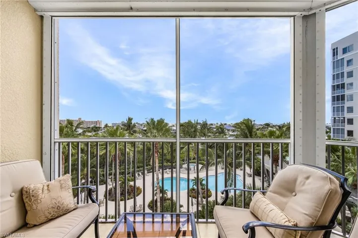 Balcony featuring a sunroom, view of pool, and grilling area