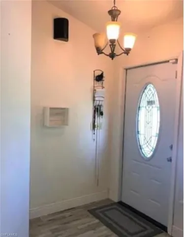 Entryway featuring light wood-type flooring and a chandelier