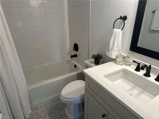 Full bathroom with vanity, toilet, and shower / bathtub combination with curtain