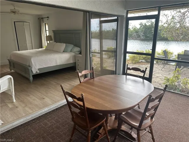 Bedroom with hardwood / wood-style flooring, a water view, and a closet