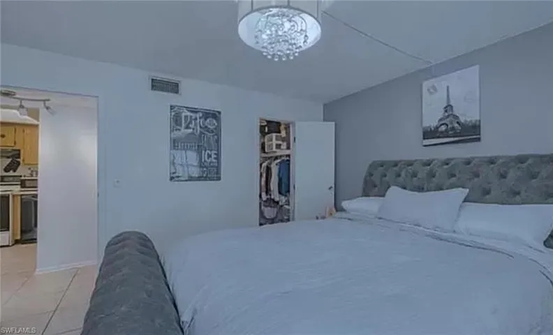 Tiled bedroom with a notable chandelier and a closet