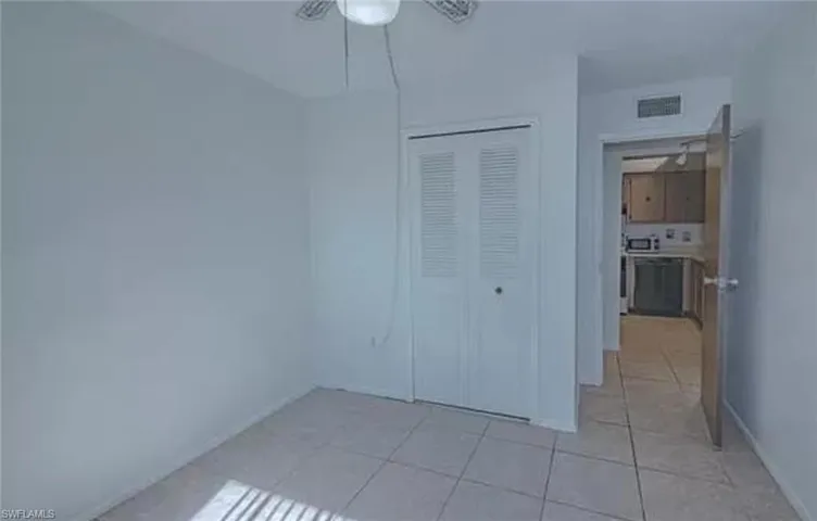 Unfurnished bedroom with a closet, ceiling fan, and light tile floors