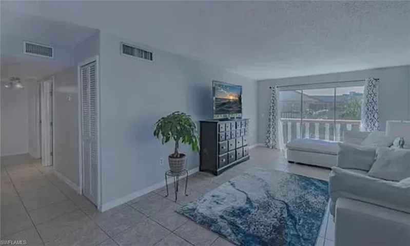 Living room with a textured ceiling and light tile floors