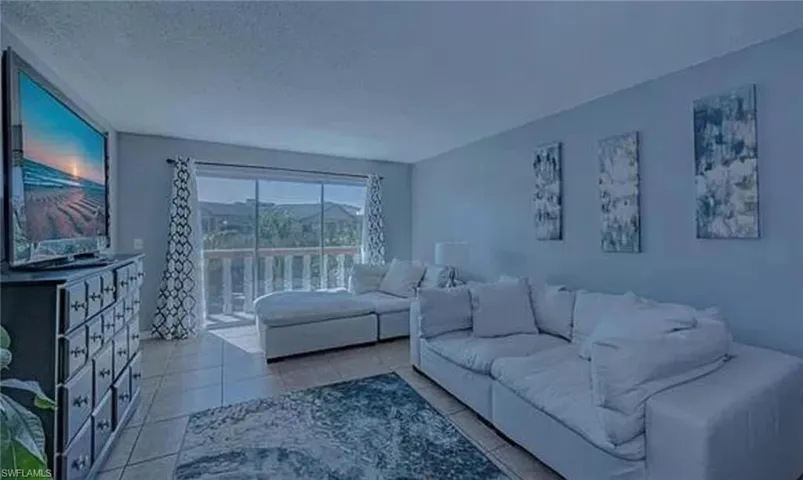 Tiled living room featuring a textured ceiling