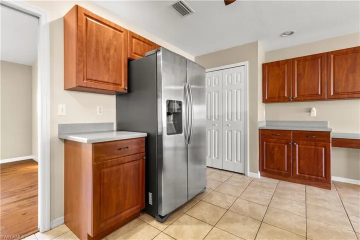Kitchen featuring stainless steel fridge and light tile patterned floors