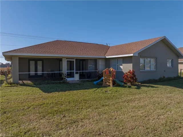 Back of property featuring a yard