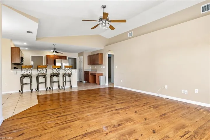 Unfurnished living room with ceiling fan, light hardwood / wood-style flooring, and lofted ceiling