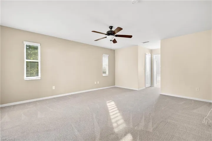 Unfurnished room with light carpet and ceiling fan