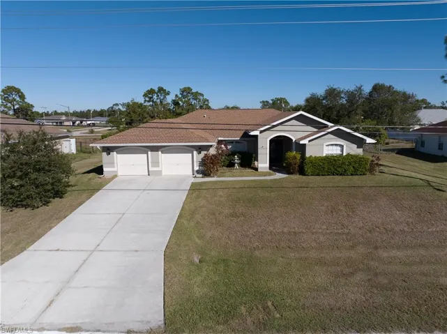 Single story home featuring a garage and a front lawn