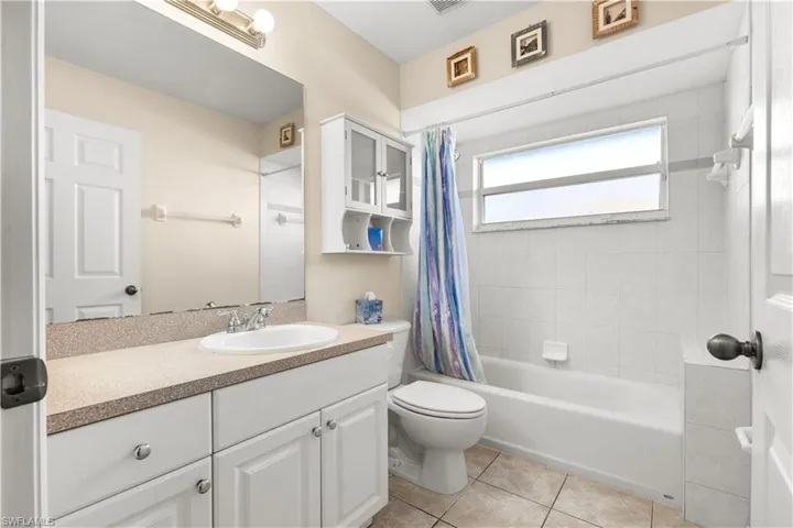 Full bathroom featuring tile patterned flooring, vanity, shower / bath combo, and toilet