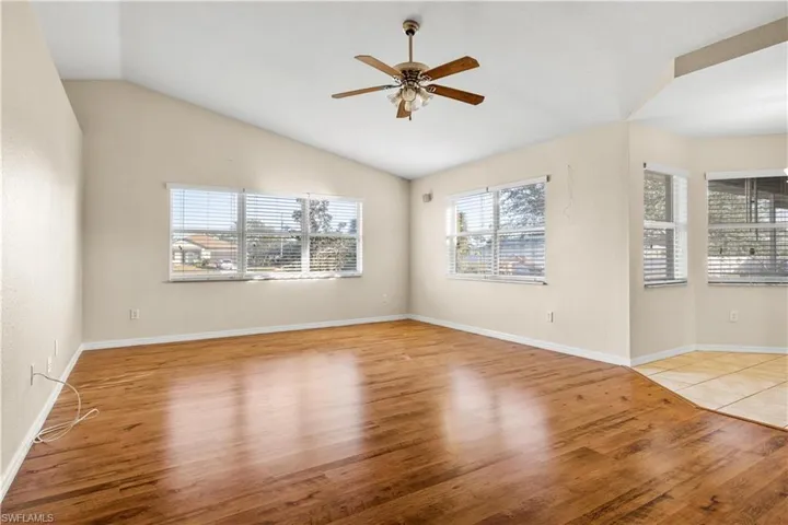 Spare room featuring vaulted ceiling, light hardwood / wood-style flooring, and ceiling fan