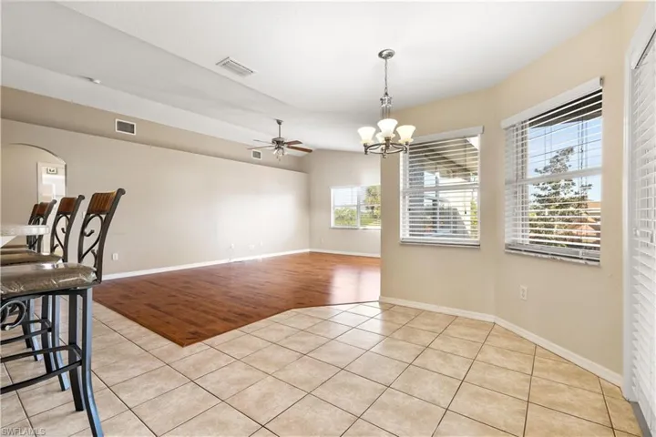 Dining space with ceiling fan with notable chandelier and light hardwood / wood-style floors