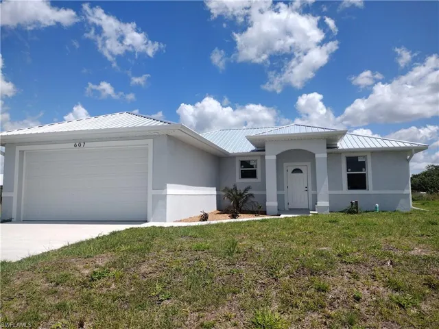 Single story home with a garage and a front lawn