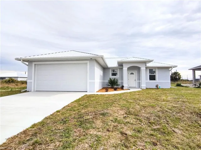 View of front of property featuring a garage and a front lawn