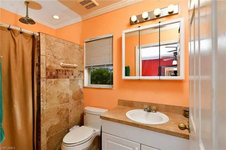 Full bathroom featuring visible vents, toilet, a shower with curtain, ornamental molding, and vanity