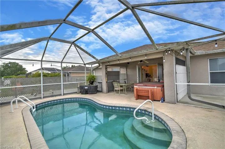 Outdoor pool with glass enclosure, a patio, a ceiling fan, and a hot tub