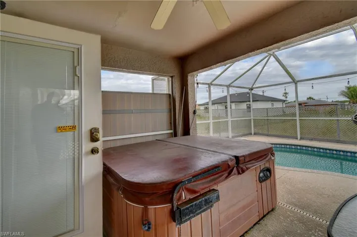 Sunroom / solarium with a hot tub and ceiling fan