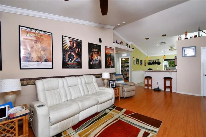 Living area with crown molding, wood finished floors, and a ceiling fan