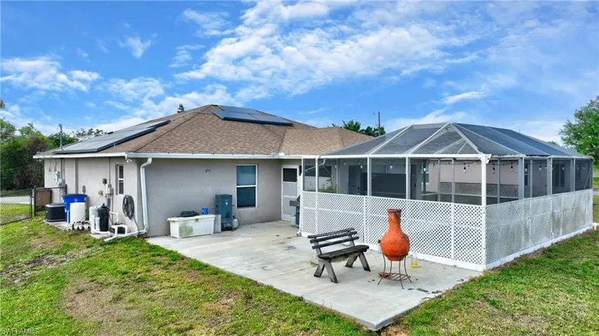 Back of property with stucco siding, a patio area, a yard, and a sunroom