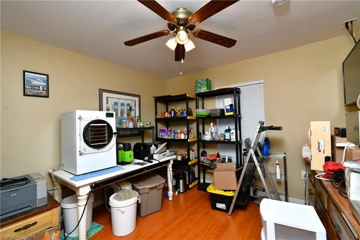 Office space with washer / clothes dryer, wood finished floors, and ceiling fan