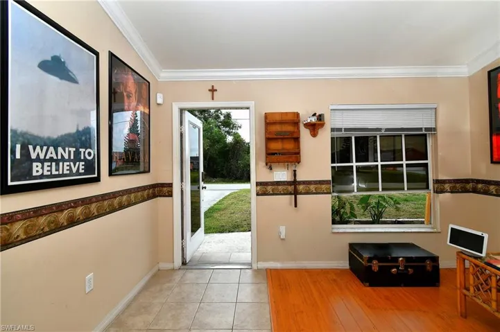 Foyer entrance with tile patterned flooring, crown molding, and baseboards