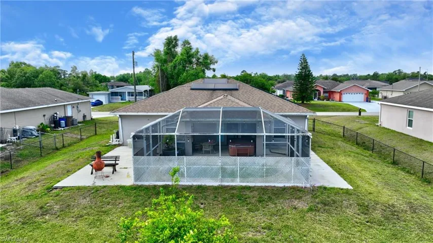 Back of property with a patio, a fenced backyard, a lanai, a lawn, and a residential view