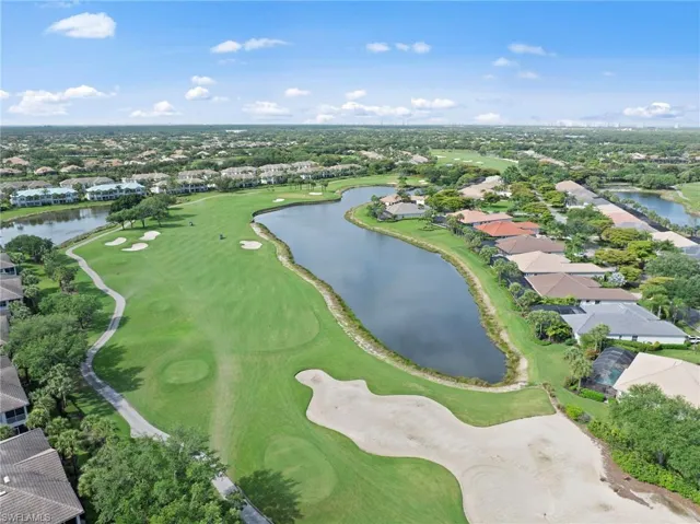 Aerial view showcasing a golf course with multiple sand bunkers and a water hazard
