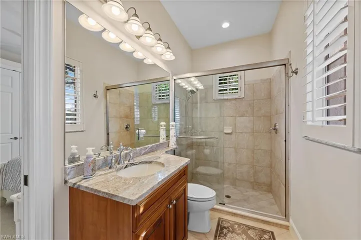 Bathroom featuring a wood vanity with a granite countertop and an undermount sink