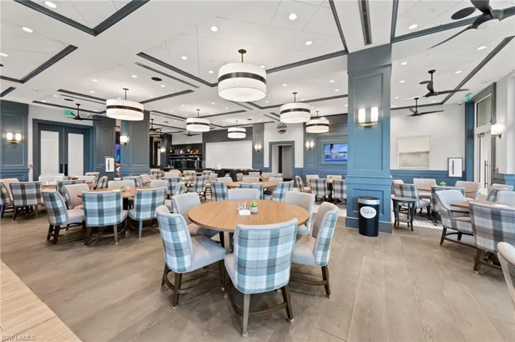 Spacious dining area featuring wood-finish flooring, recessed lighting, and decorative ceiling details