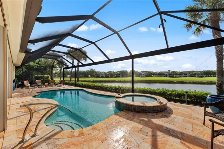 Screened lanai featuring a freeform swimming pool with integrated spa