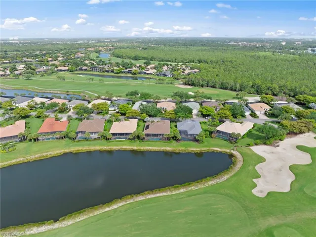 Aerial perspective showcasing a residential community situated alongside a golf course and multiple water features