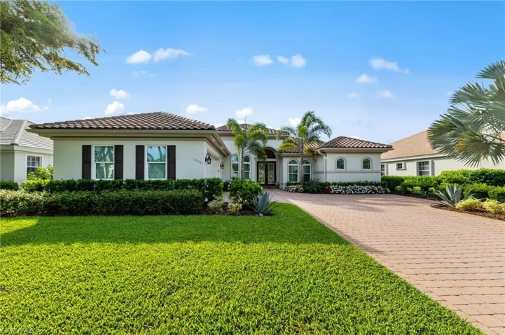 Exterior facade featuring a tile roof, stucco finish, and decorative window shutters