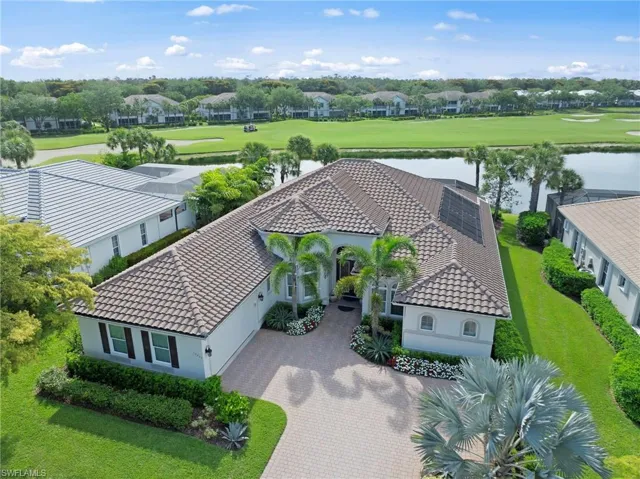 Mediterranean-inspired residence featuring a tile roof, paver driveway, and manicured landscaping