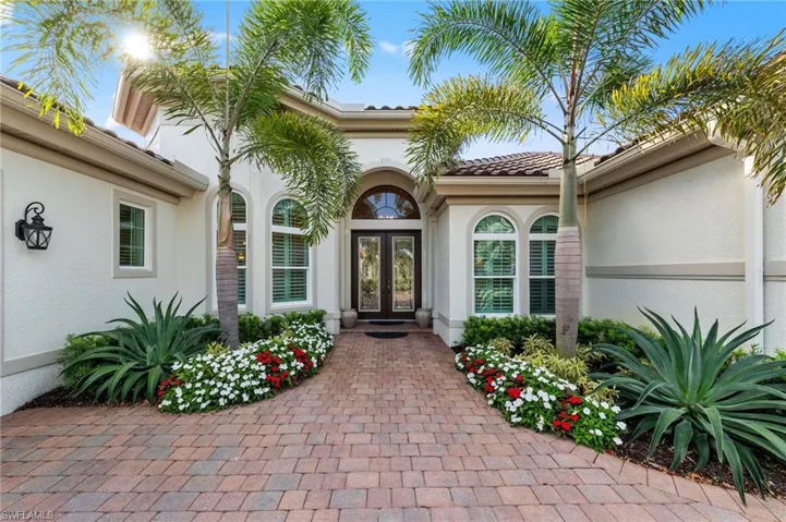 Mediterranean-style stucco exterior with a tile roof and decorative arched entry