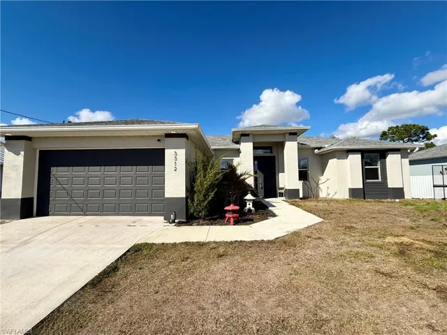 Prairie-style home with stucco siding, driveway, and a garage