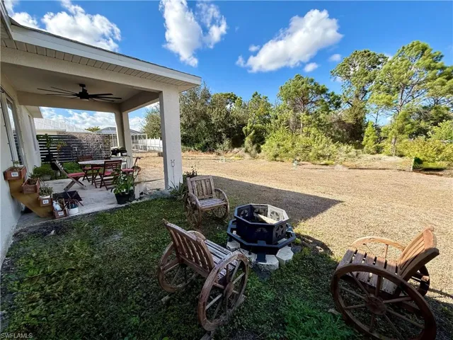 View of yard with ceiling fan, a patio, and a fire pit