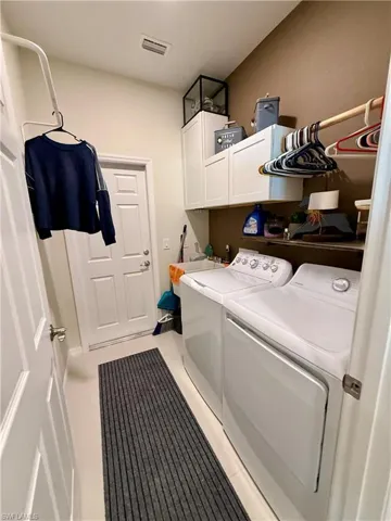 Laundry area featuring cabinet space and separate washer and dryer