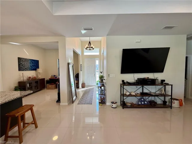Foyer entrance featuring light tile patterned floors and suspended lighting