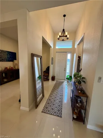 Entryway featuring a chandelier, a high ceiling, and light tile patterned floors
