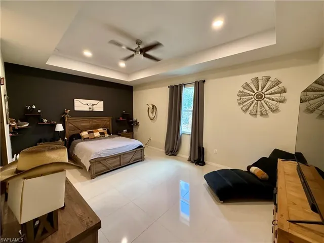 Bedroom featuring recessed lighting, a ceiling fan, tile patterned flooring, and a raised ceiling