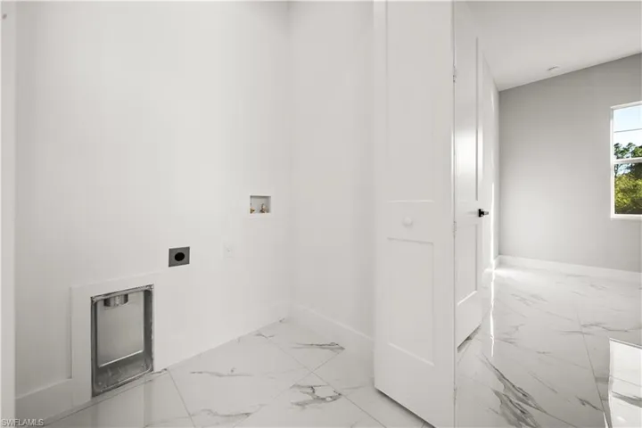 Clothes washing area featuring baseboards, marble finish floor, electric dryer hookup, laundry area, and washer hookup